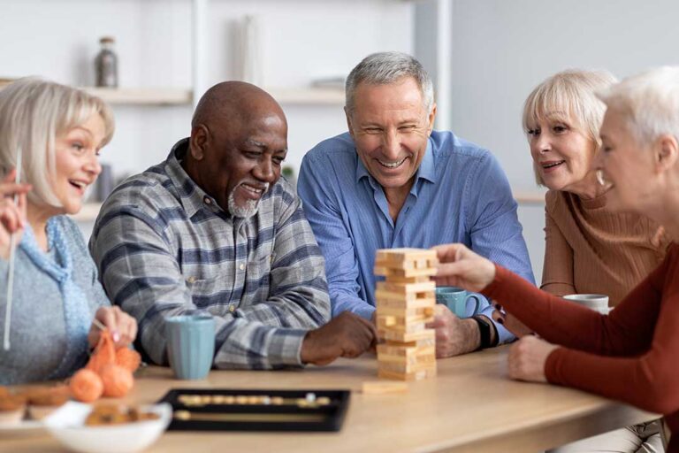 Adult daughter sits beside her elderly mother, sharing a photo album in a cozy assisted living apartment.