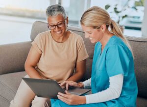 Family caregiver reviewing a care plan with an older adult at a kitchen table.